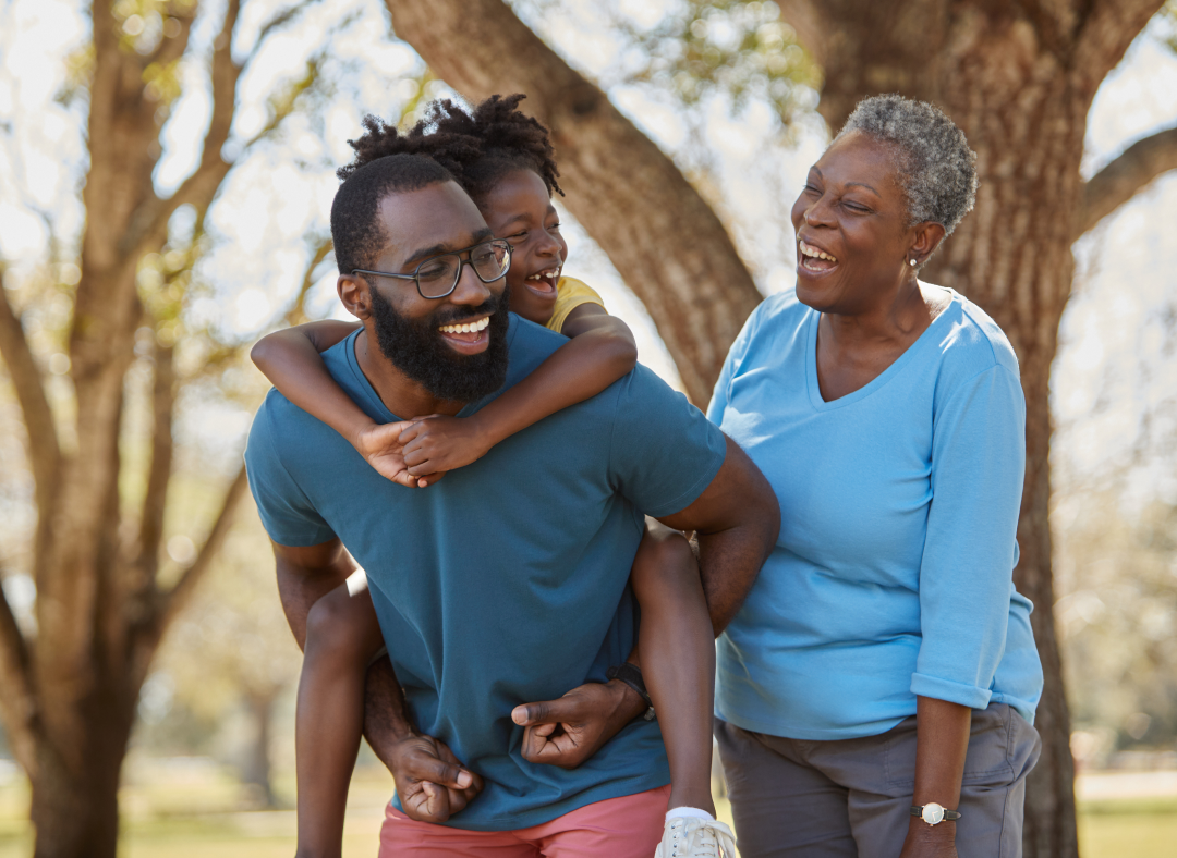 Una familia sonriendo feliz al aire libre​​ 